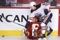 Edmonton Oilers' Gaetan Haas, top runs over Calgary Flames' Derek Ryan during the second period of an NHL hockey game Saturday, April 10, 2021, in Calgary, Alberta. (Larry MacDougal/The Canadian Press via AP)