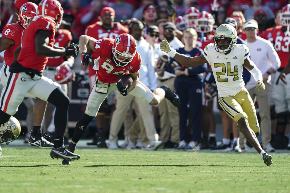 Georgia wide receiver Ladd McConkey (84) returns a punt as Georgia Tech defensive back Kenan Johnson (24) closes in during the first half of an NCAA college football game Saturday, Nov. 26, 2022 in Athens, Ga. (AP Photo/John Bazemore)