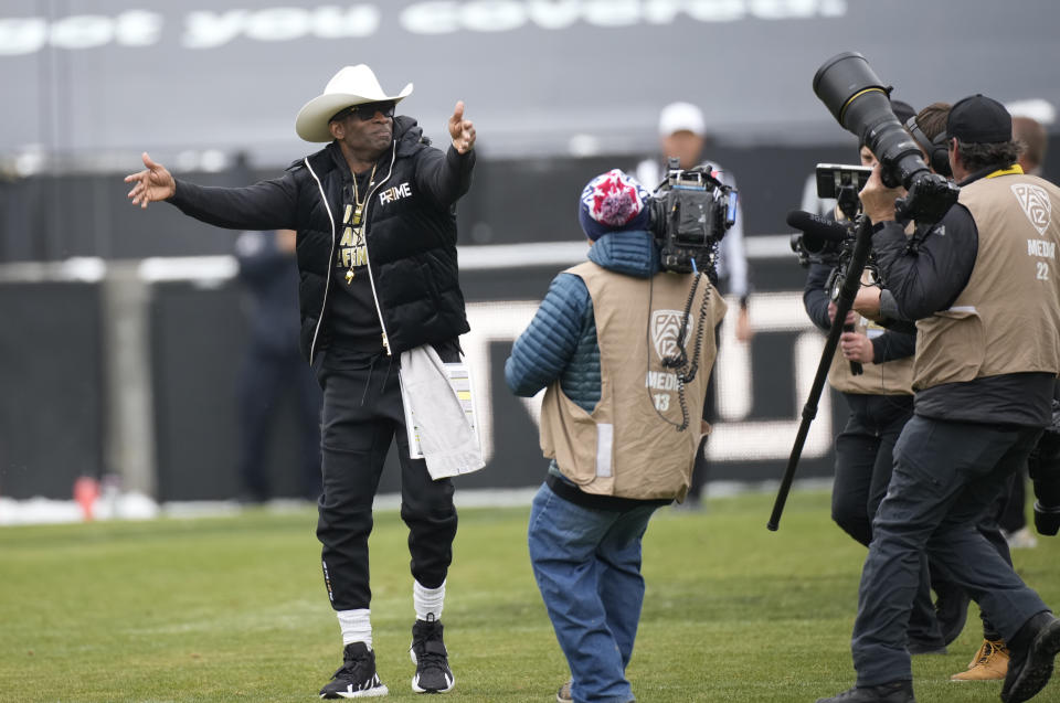 Colorado head coach Deion Sanders exhorts fans as he steps on to the field for the team's spring NCAA college football game Saturday, April 22, 2023, in Boulder, Colo. (AP Photo/David Zalubowski)