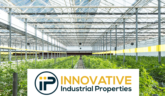 Interior of a large marijuana-growing greenhouse, with the company's name and logo at the bottom of the image.