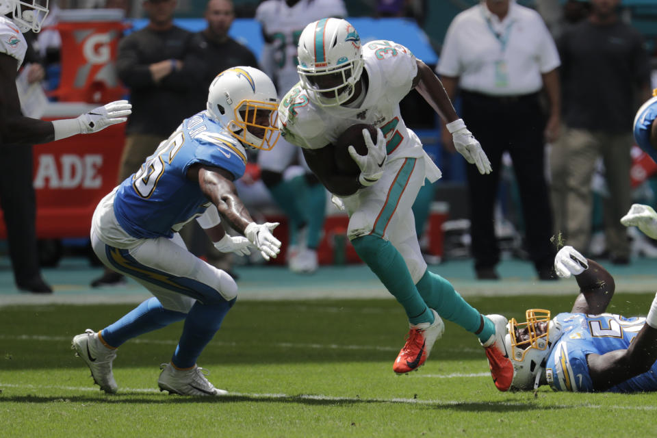 Los Angeles Chargers cornerback Casey Hayward (26) attempts to tackle Miami Dolphins running back Kenyan Drake (32), during the first half at an NFL football game, Sunday, Sept. 29, 2019, in Miami Gardens, Fla. AP Photo/Lynne Sladky)