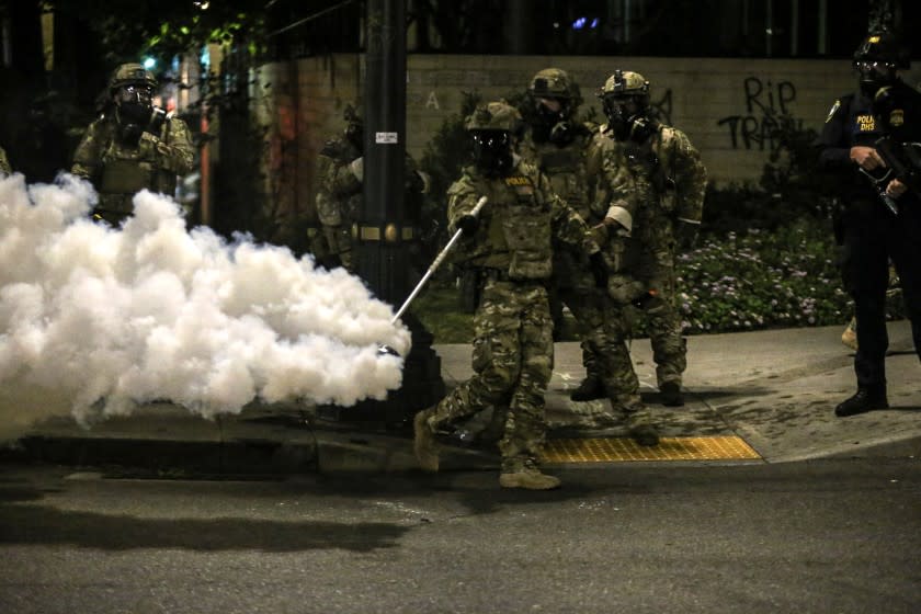 Militarized federal agents deployed by the president to Portland, fired tear gas against protesters again overnight Friday, July 17, 2020 in Portland, Ore. as the city's mayor demanded that the agents be removed and as the state's attorney general vowed to seek a restraining order against them.(Dave Killen/The Oregonian via AP)