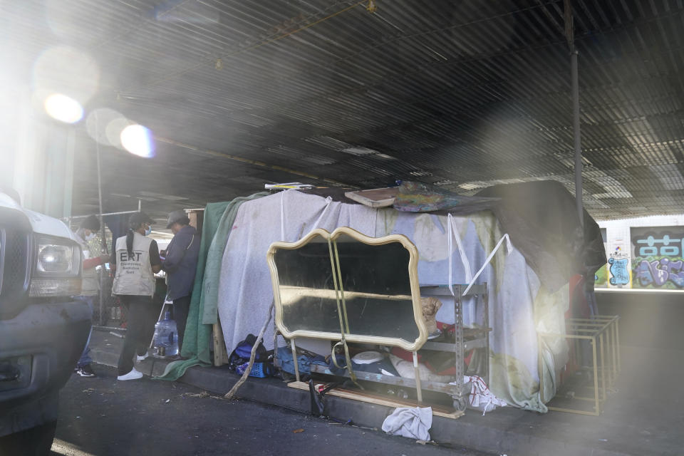 Members of the San Francisco Homeless Outreach Team's Encampment Resolution Team speak with people at an encampment in San Francisco, Tuesday, Aug. 29, 2023. Cities across the U.S. are struggling with and cracking down on tent encampments as the number of homeless people grows, largely due to a lack of affordable housing. Homeless people and their advocates say sweeps are cruel and costly, and there aren't enough homes or beds for everyone. (AP Photo/Jeff Chiu)