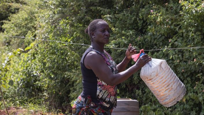 Woman hanging a bottle on a line