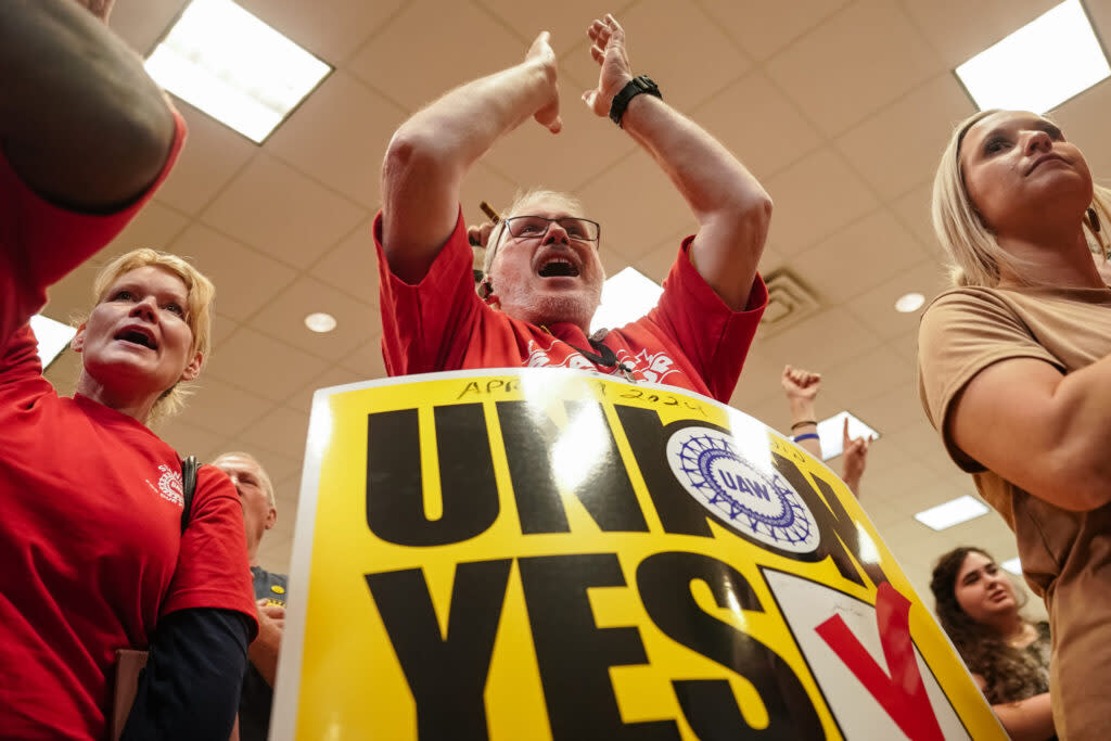 A man applauding and holding a sign saying "Union Yes"