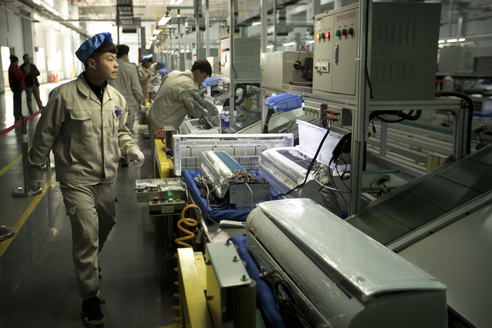 In this Friday, Feb. 24, 2017 photo, factory workers check air conditioners on an assembly line at a Haier factory in Jiaozhou near Qingdao in eastern China's Shandong Province. Zhang Ruimin built Haier from a failing refrigerator factory in the 1980s into the biggest maker of major appliances. Now, he is trying to transform a traditional manufacturer with 60,000 employees in 25 countries into a nimble, Internet Age seller of consumer goods and services from web-linked washing machines to food delivery. (AP Photo/Mark Schiefelbein)