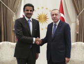 Turkey's President Recep Tayyip Erdogan, right, and Qatar's Emir Sheikh Tamim bin Hamad Al Thani shake hands before their talks in Ankara, Turkey, Wednesday, Aug. 15, 2018. Sheikh Al Thani is in Turkey for a one-day working visit.(Presidential Press Service via AP, Pool)