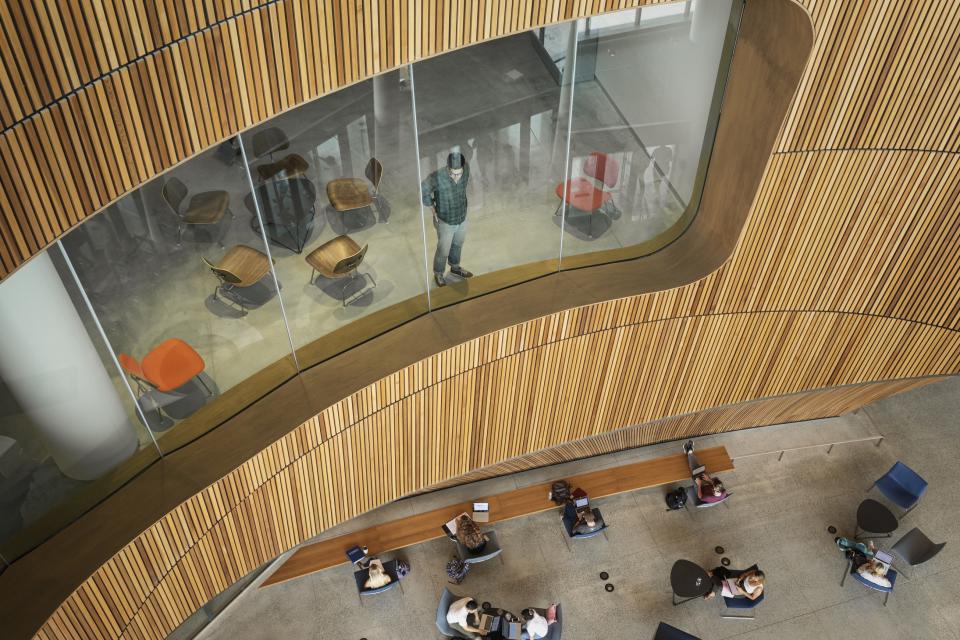 The architectural team prioritized visual transparency throughout the building. Here, a student looks through a third-floor window down to the lobby in the library’s new “scholar studio.”