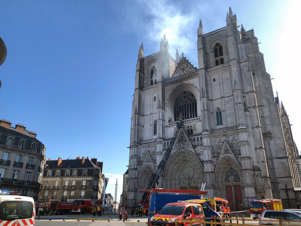 Fire fighters brigade work to extinguish the blaze at the Gothic St. Peter and St. Paul Cathedral, in Nantes, western France, Saturday, July 18, 2020. The fire broke, shattering stained glass windows and sending black smoke spewing from between its two towers of the 15th century, which also suffered a serious fire in 1972. The fire is bringing back memories of the devastating blaze in Notre Dame Cathedral in Paris last year that destroyed its roof and collapsed its spire and threatened to topple the medieval monument. (AP Photo/Laetitia Notarianni)
