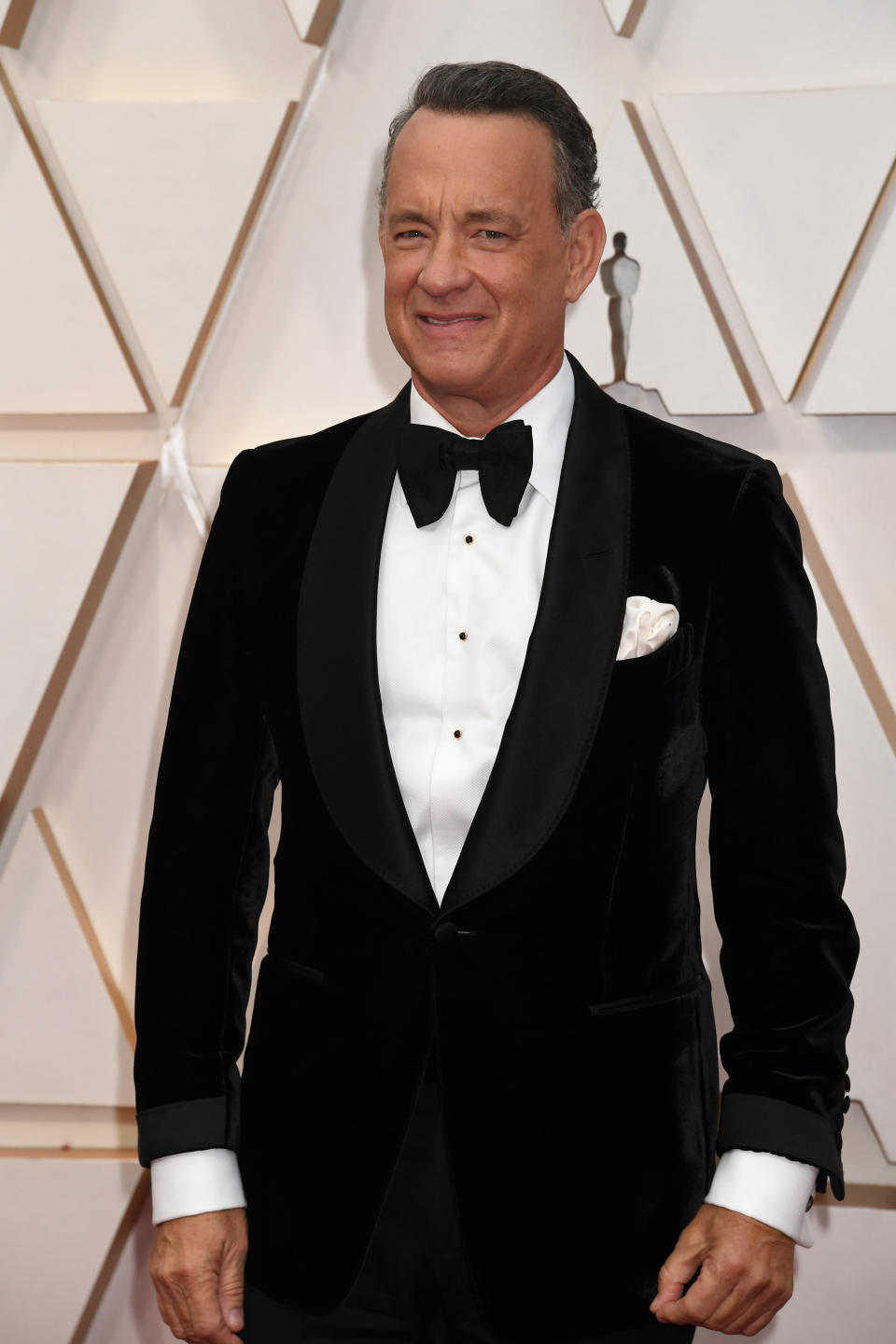 tom hanks smiling during a portrait while on the red carpet