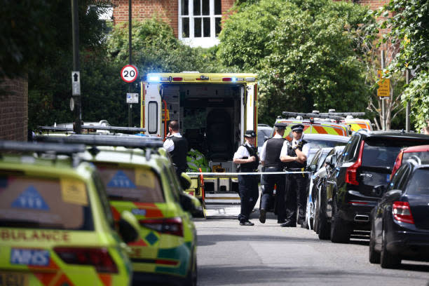 Police officers stand guard next to an ambulance behind a cordon following a car collision at the private Study Prep girls’ school in Wimbledon, southwest London, on 6 July 2023 (AFP via Getty Images)