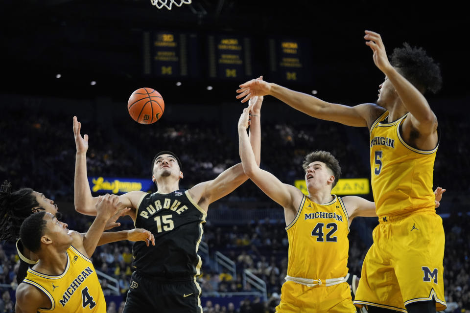 Purdue center Zach Edey (15) battles with Michigan guard Nimari Burnett (4), Will Tschetter (42) and Terrance Williams II (5) for a rebound in the first half of an NCAA college basketball game in Ann Arbor, Mich., Sunday, Feb. 25, 2024. (AP Photo/Paul Sancya)