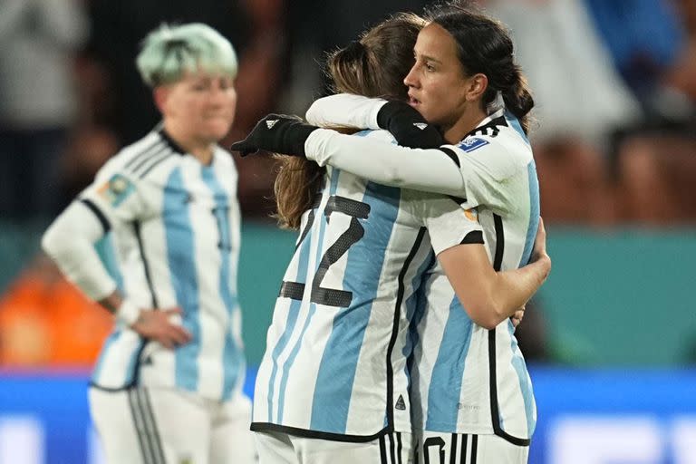 Estefanía Banini y Dalila Ippolito se abrazan tras el 2-0 condenatorio de Suecia; detrás, sufre Yamila Rodríguez, porque Argentina acaba de quedar eliminada del Mundial Australia-Nueva Zelanda 2023.
