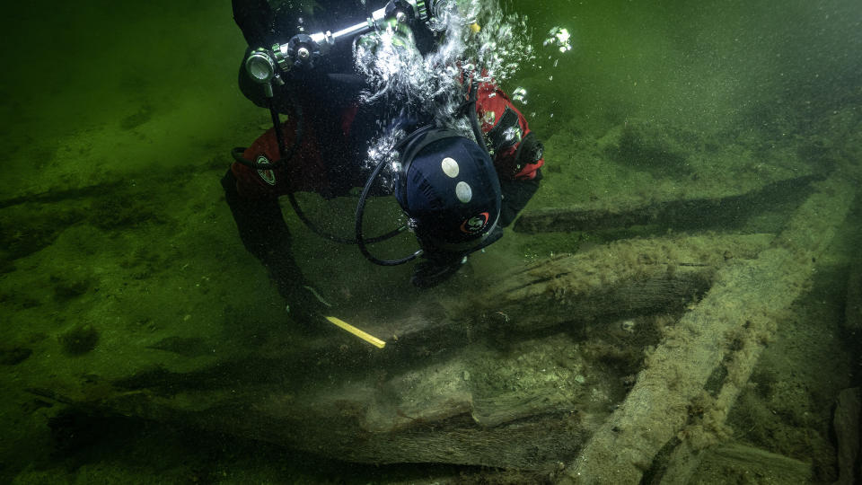 A scuba diver looking at the shipwreck.