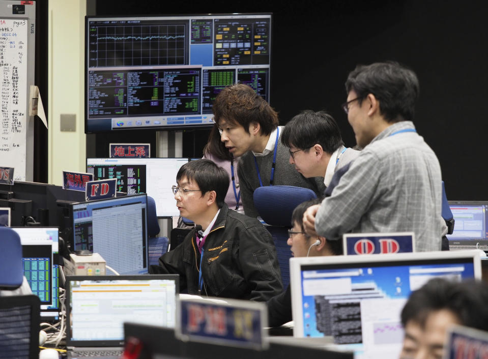 In this photo provided by the Japan Aerospace Exploration Agency (JAXA), staff of the Hayabusa2 Project watch monitors for a safety check at the control room of the JAXA Institute of Space and Astronautical Science in Sagamihara, near Tokyo, Thursday, Feb. 21, 2019. Japanese spacecraft Hayabusa2 is approaching the surface of the asteroid Ryugu about 280 million kilometers (170 million miles) from Earth. JAXA said Thursday that Hayabusa2 began its approach at 1:15 p.m. (ISAS/JAXA via AP)