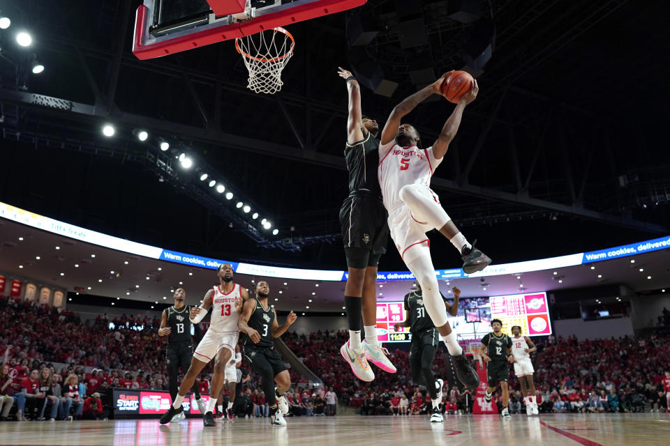 Houston's Ja'Vier Francis (5) goes up for a shot as Central Florida's Michael Durr defends during the first half of an NCAA college basketball game Saturday, Dec. 31, 2022, in Houston. (AP Photo/David J. Phillip)