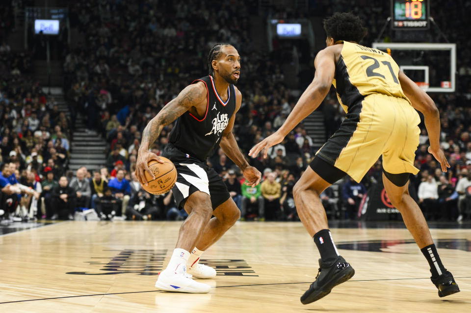 Los Angeles Clippers forward Kawhi Leonard, left, looks to the net while defended by Toronto Raptors forward Thaddeus Young (21) during the first half of an NBA basketball game in Toronto, Friday, Jan. 26, 2024. (Christopher Katsarov/The Canadian Press via AP)