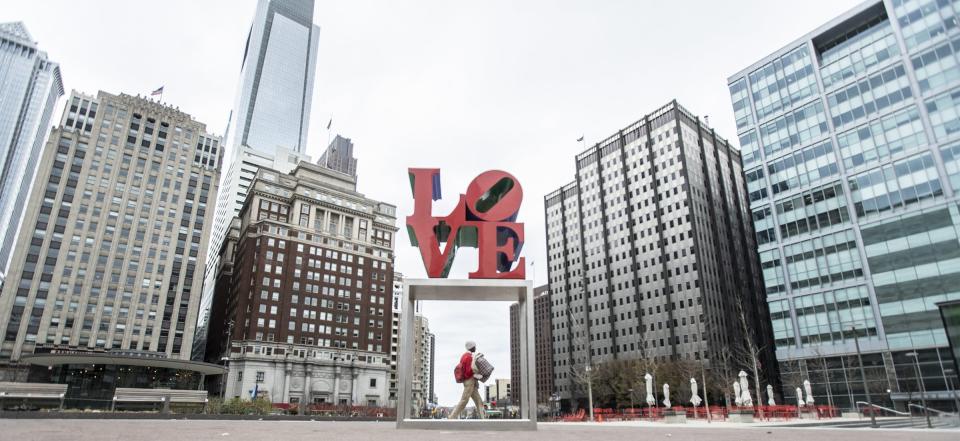 Love Park was almost completely deserted except for one pedestrian passing through, Sunday March 22, 2020 in Philadelphia. Philadelphia is issuing a stay-at-home order that begins Monday, after Gov. Tom Wolf has already asked residents to stay home, if they can help it, and ordered non-life-sustaining businesses to close. (Michael Bryant/The Philadelphia Inquirer via AP)