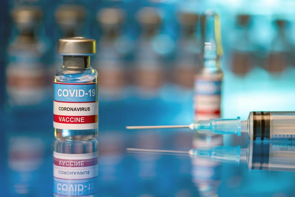 Indoor shot of vaccine test samples - with reflections of glass vials and syringe