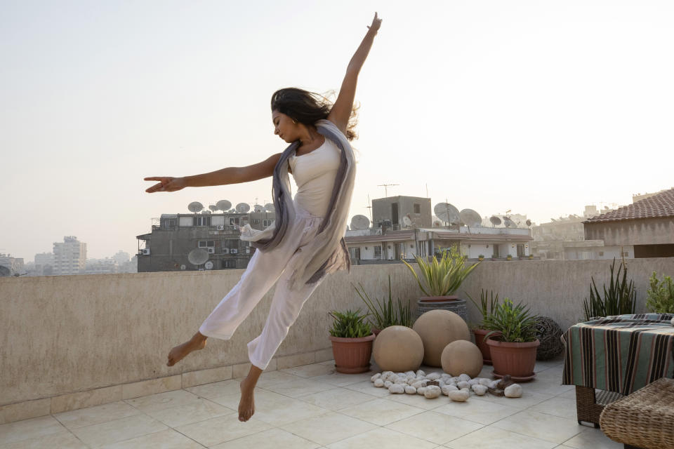 Egyptian 26-year-old dancer Nadine El Gharib, dances on the rooftop of her home in Cairo, Egypt, Monday, Sept. 27, 2021. "Dance was crucial when COVID-19 started in terms of taking care of my well-being," Gharib said. "When restrictions forced us to stop going to the Opera for classes I started online dance and it introduced me to a new world of dance. It was very inspiring." (AP Photo/Nariman El-Mofty)