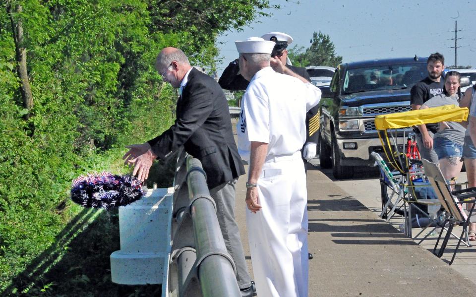 Wooster Mayor Bob Breneman drops a wreath into the water to honor those killed at sea.