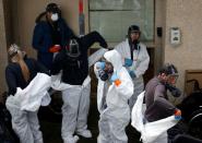 Servpro cleaning crew workers take off their protective suits at Life Care Center of Kirkland