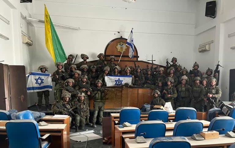 Tropas de la Brigada Golani de las FDI posan con una bandera israelí en el interior del edificio del Parlamento de Gaza, en la calle principal Omar Al-Mukhtar de la ciudad de Gaza, tras tomar el lugar.