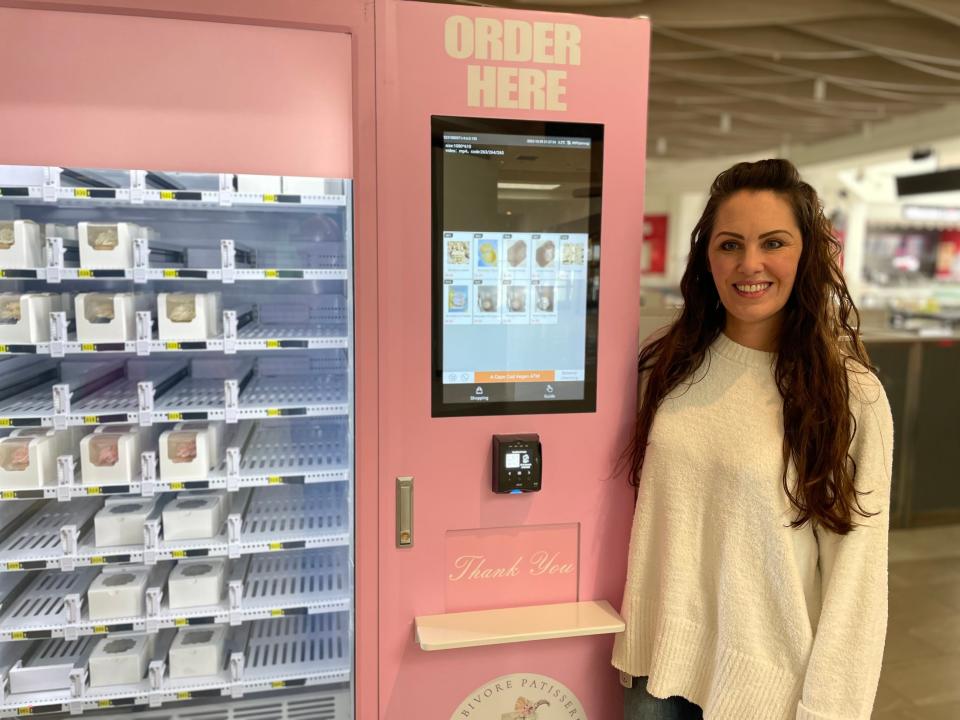 Brandy Walsh, owner of Herbivore Patisserie, with the vegan desserts vending machine she had installed at Cape Cod Mall for the holidays.