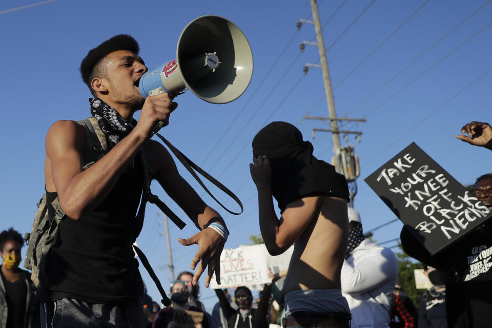 A protester uses a megaphone June 10 while blocking a street outside the police station in Florissant, Missouri. Several hundred protesters were calling attention to a video that appears to show a Florissant police detective, who has since been fired, striking a man with his police car during a recent pursuit. (Photo: Jeff Roberson/Associated Press)