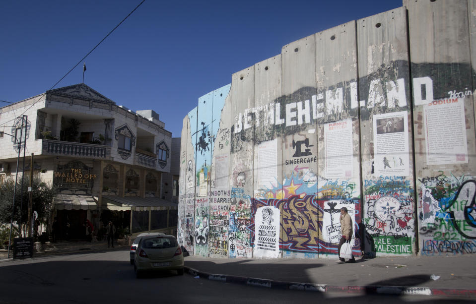 The Israeli security barrier stands near The Walled Off Hotel where a new artwork dubbed "scar of Bethlehem" by artist Banksy is displayed in the West Bank city of Bethlehem, Sunday, Dec. 22, 2019. (AP Photo/Majdi Mohammed)