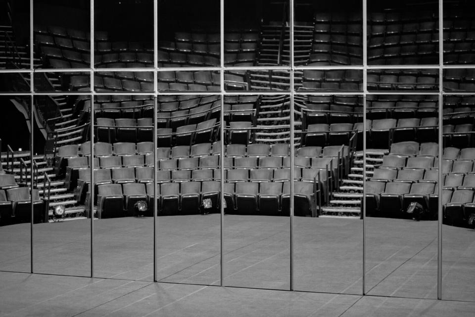 Empty seats are reflected in a mirrored set.