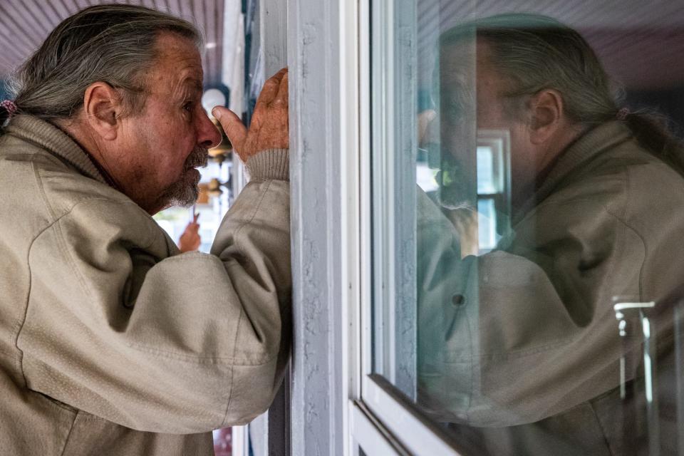 Gary Wagoner, brother of Linda Wagoner, who was former Indianapolis Colts quarterback Art Schlichter's attorney, peeks inside his sister's foreclosed home.