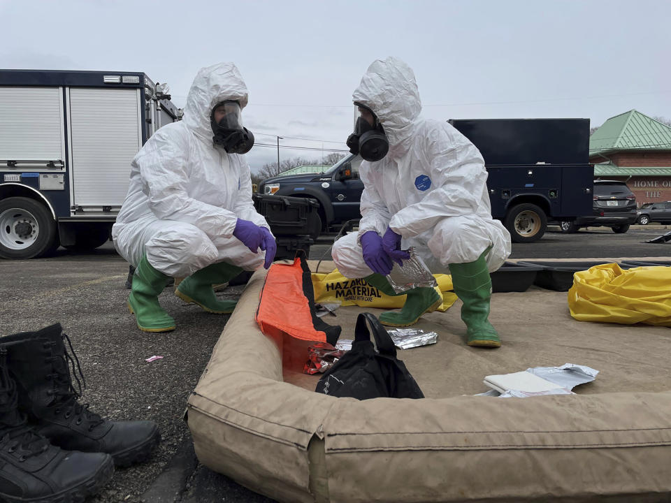 This photo provided by the Ohio National Guard, ONG 52nd Civil Support Team members prepare to enter an incident area to assess remaining hazards with a lightweight inflatable decontamination system (LIDS) in East Palestine, Ohio, Tuesday, Feb. 7, 2023. Authorities say air monitoring hasn’t detected dangerous levels of fumes in communities where crews released and burned toxic chemicals from a derailed train. But they said Tuesday that Ohio and Pennsylvania residents living close to the wreckage still aren’t being allowed in their homes.(Ohio National Guard via AP)