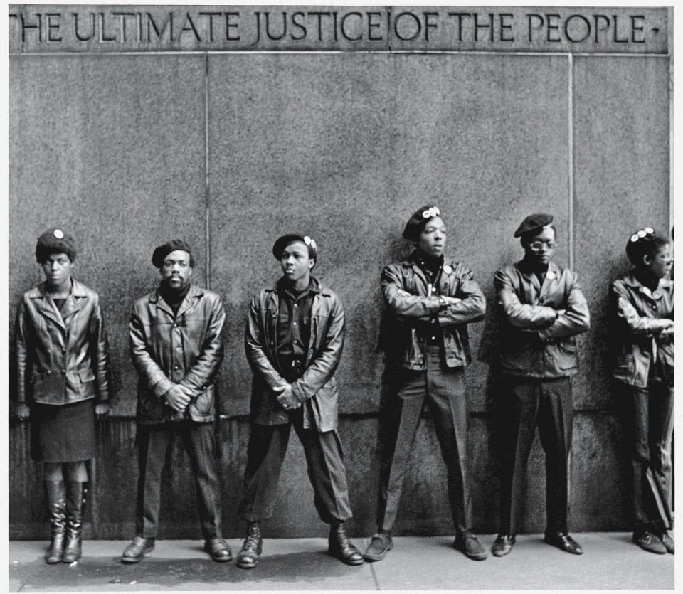 View of a line of Black Panther Party members as they stand outside the New York City courthouse under a portion of an Abraham Lincoln quote which reads 'The Ultimate Justice of the People,' New York, New York, April 11, 1969.