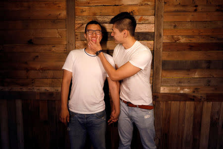 Huang Chen-ting (L), 30, a school administrator and Lin Chi-xuan, 28, a personal trainer, pose for a photograph in Taipei, Taiwan, May 16, 2017. REUTERS/Tyrone Siu