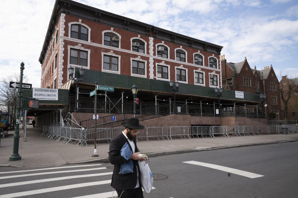 FILE - A man passes the Chabad-Lubavitch World Headquarters in the Crown Heights neighborhood of Brooklyn, Tuesday, April 7, 2020 in New York. The building, normally open for prayer, is closed due to the coronavirus pandemic. The synagogue in New York's Brooklyn borough is closely tied with Rabbi Menachem Mendel Schneerson's enduring influence in global Judaism and beyond in the three decades since his death, but it received unwanted attention in January 2024 with a brawl between some worshippers and police, part of a sequence of events that began with the discovery of a secretly dug tunnel. (AP Photo/Mark Lennihan, File)