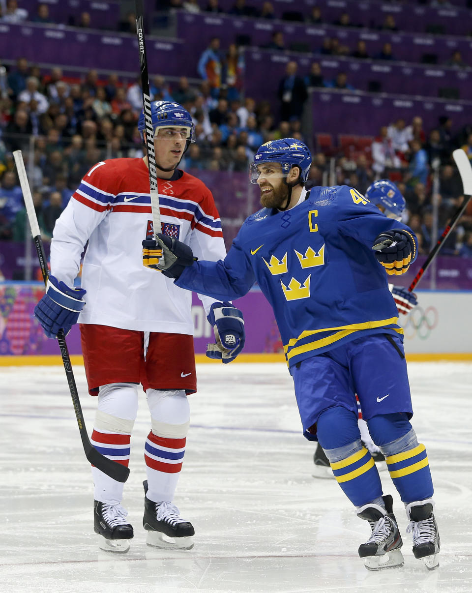 Sweden forward Henrik Zetterberg, right, reacts in front of Czech Republic defenseman Tomas Kaberle after Sweden scored a goal in the second period of a men's ice hockey game at the 2014 Winter Olympics, Wednesday, Feb. 12, 2014, in Sochi, Russia. (AP Photo/Mark Humphrey)