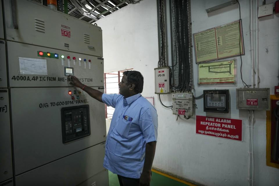 El electricista A. Prakash comprueba el parámetro del disyuntor de salida de un sistema de almacenamiento de energía en batería de 500 kilovatios en el interior de la fábrica de Hindustan Coca-Cola Beverages en el distrito de Thiruvallur, en las afueras de Chennai, India, el martes 16 de julio de 2024. (Foto AP/Mahesh Kumar A.)