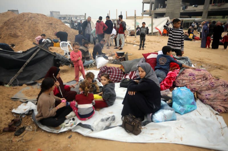 Displaced Palestinians who fled from Khan Younis, sit with their belongings at makeshift shelters in Rafah in the southern Gaza Strip border with Egypt on December 4. File Photo by Ismael Mohamad/UPI