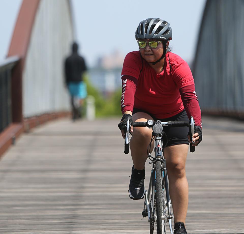 A cyclist rides on the Jack A. Markell Trail on a hot summer day.
