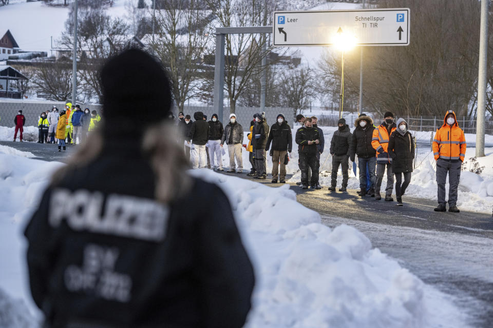 FILE - In this Monday, Jan. 25, 2021 file photo, people wait in front of a coronavirus test station at the German-Czech Republic border in Furth im Wald, Germany. The European Union's executive body proposed Monday that the bloc's 27 nations impose more travel restrictions to counter the worrying spread of new coronavirus variants but make sure to keep goods and workers moving across EU borders. (Armin Weigel/dpa via AP, File)