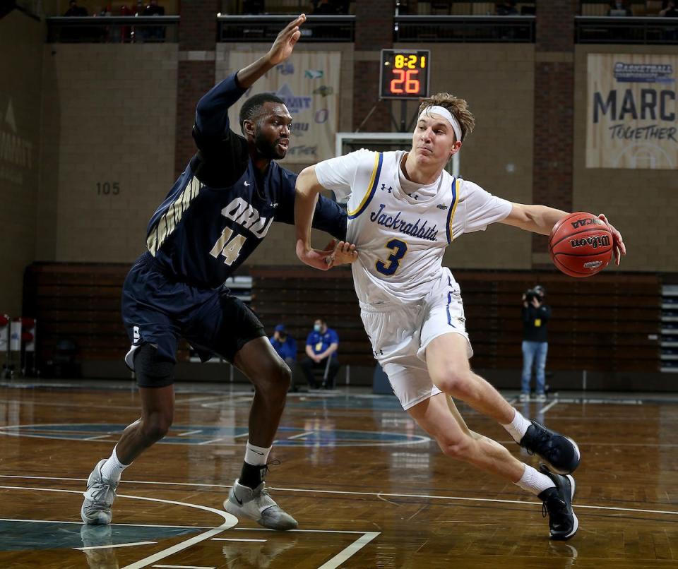 SIOUX FALLS, SD - MARCH 8: Baylor Scheierman #3 of the South Dakota State Jackrabbits drives to the basket against DeShang Weaver #14 of the Oral Roberts Golden Eagles during the Summit League Basketball Tournament at the Sanford Pentagon in Sioux Falls, SD. (Photo by Dave Eggen/Inertia)