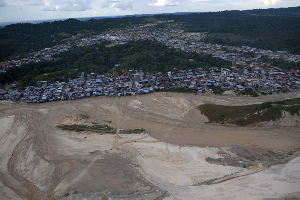 The city of Huepetuhe in Peru's Madre de Dios region is seen from a helicopter, Monday, April 28, 2014. Soldiers, police and marines have begun destroying illegal gold mining machinery in Peru’s southeastern jungle region of Madre de Dios. Authorities began enforcing a ban on illegal mining Monday in the Huepetuhe district. They had given the state’s illegal miners until April 19 to get legal or halt operations. (AP Photo/Rodrigo Abd)