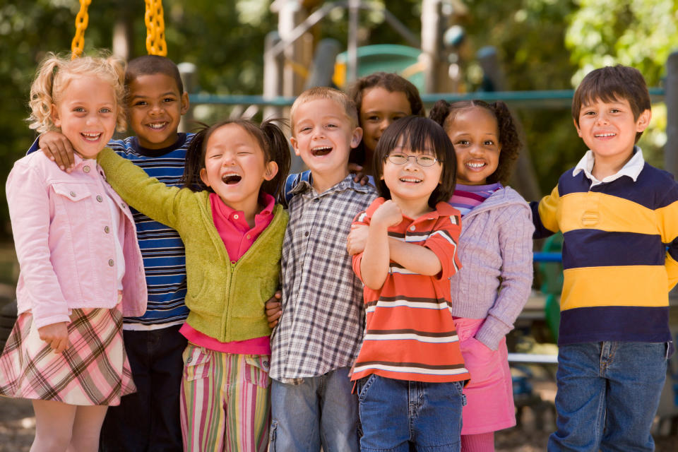 Eight children ostensibly at recess pose together for a picture