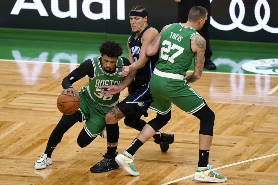 Boston Celtics guard Marcus Smart (36) dribbles the ball as center Daniel Theis (27) sets a screen against Orlando Magic forward Aaron Gordon during the first half of an NBA basketball game Friday, Jan. 15, 2021, in Boston. (AP Photo/Elise Amendola)