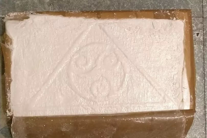 A kilo block of cocaine with what appears to be a triskele within a triangle motif -Credit:Crown Office