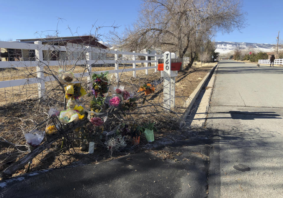 A makeshift memorial of several dozen bouquets and a candle are shown Thursday, Jan. 24, 2019, outside the south Reno, Nev., home of Gerald David, 81, and his 80-year-old wife, Sharon, whose bodies were found inside on Jan. 16. Authorities have arrested a man on suspicion of being in the U.S. illegally in the deaths of the Davids and two other people over the past two weeks. (AP Photo/Michelle L. Price)