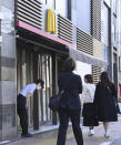 A McDonald's employee bows in front of its store amid their system outages in Tokyo, Friday, March 15, 2024. Reports of system outages at McDonald's are growing around the world, shuttering restaurants and leading to social media complaints. McDonald's in Japan posted on X, formerly Twitter, that “operations are temporarily out at many of our stores nationwide."(Kyodo News via AP)