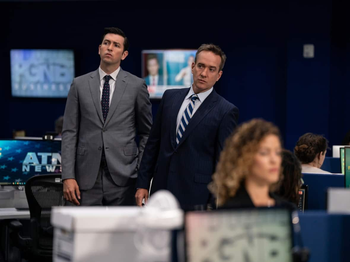 Characters Greg Hirsch, left, and Tom Wambsgans roam the newsroom, inseparable as always, in this scene from Succession. (HBO - image credit)