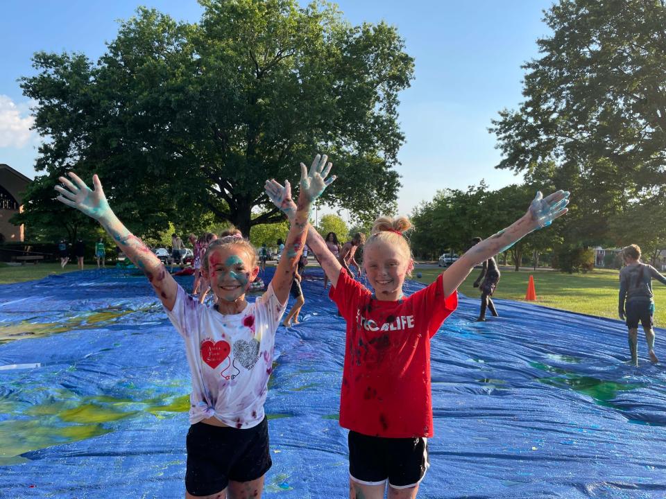 Caroline Nichols, 11, and Kinsley Copeland, 11, strike a pose while covered in slime at a slime battle at Concord United Methodist Church on Wednesday, June 23, 2022